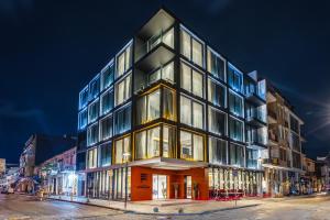 a tall building on a city street at night at Piazza Epigraph in Batumi