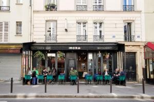 a group of people sitting outside of a restaurant at Élégance Urbaine - 2 chambres in Paris
