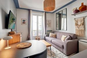 a living room with a couch and a table at Élégance Urbaine - 2 chambres in Paris