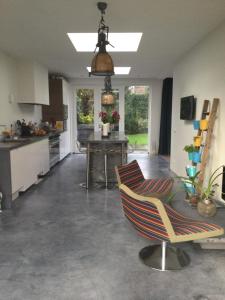 a kitchen with a chair in the middle of a room at Villa Cosy Central incl Jacuzzi Near trainstation, beach and city in Heemstede +49 photos