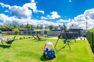 a childs playground with a toy car and swings at Apartamenty Sea Colors - Basen i Sauna! Blisko Plaży - Bardzo Wysoki Standard in Jastrzębia Góra