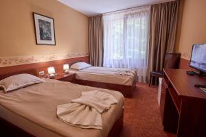 a hotel room with two beds and a television at Хотел "Калина" in Borovets