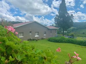 a house with a large yard with a grass field at Rondebossie Farm Retreat in Magoebaskloof