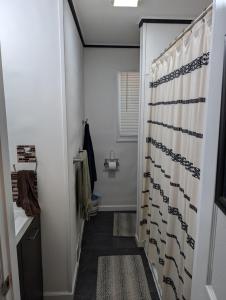 a bathroom with a shower with a shower curtain at Landry's Laire in Crescent