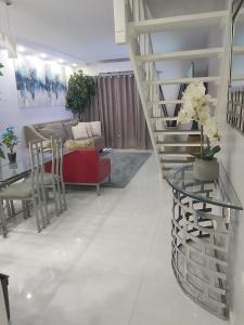 un soggiorno con scala e divano rosso di The Island Flat Villa - Near Airport & Beach a Montego Bay