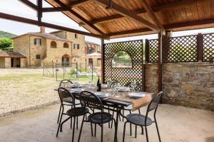 una mesa de madera y sillas en un patio al aire libre en Villa Pasqualina by Mmega, en Arezzo 28 fotos más