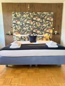 a bedroom with a bed with a large headboard at Villa Fantasia Budget Boutique Hotel in Füssen