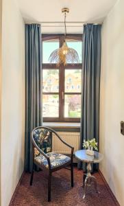 a chair and a table in a room with a window at Villa Fantasia Budget Boutique Hotel in Füssen