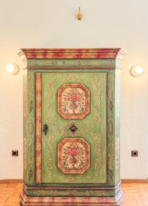 a green cabinet with a painting on it in a room at Villa Fantasia Budget Boutique Hotel in Füssen