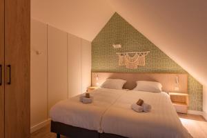 a bedroom with a large bed with two towels on it at Summio Parc Aquadelta in Bruinisse