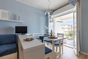 a kitchen and living room with a blue couch and a table at Conero Suite in Marcelli