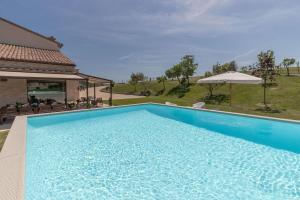 a large blue swimming pool next to a house at Italian Experience-Villa Clair in Fermo