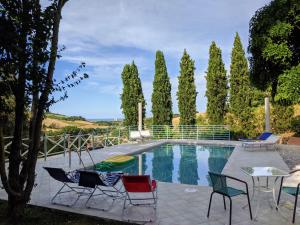 basen z krzesłami, stołem i drzewami w obiekcie Italian Experience-Villa Millefiori w mieście Porto San Giorgio
