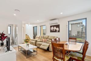 a living room with a table and a couch at Ventura Delight Townhouse with Parking and Patio in Auckland