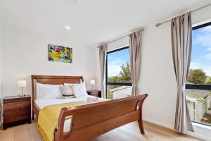 a bedroom with a bed and a large window at Ventura Delight Townhouse with Parking and Patio in Auckland