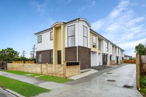 a house with a fence in front of it at Ventura Delight Townhouse with Parking and Patio in Auckland