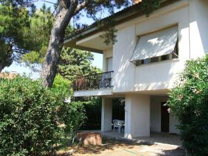 a white house with a balcony and a tree at Italian Experience-Casa Argentario in Giannella