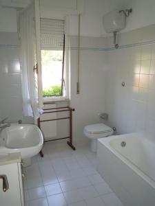 biała łazienka z wanną, toaletą i umywalką w obiekcie Italian Experience-Casa Argentario w mieście Giannella