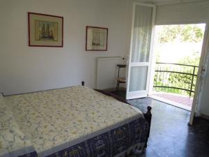 sypialnia z łóżkiem i drzwiami prowadzącymi na balkon w obiekcie Italian Experience-Casa Argentario w mieście Giannella