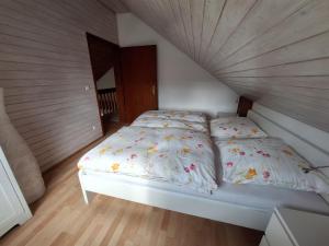 a white bed in a bedroom with a wooden ceiling at Ferienchalet Hechingen in Hechingen