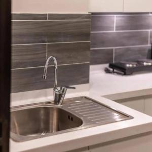 a kitchen sink with a faucet on a counter at BNR - The Opus Residences - Studio Luxury Apartment Gulberg in Lahore +18 photos