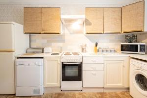 Una cocina con electrodomésticos blancos y gabinetes de madera. en Host & Stay - Summerhill Court Lodges, en Alnwick 31 fotos más