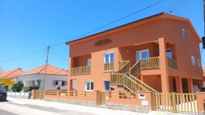 a large orange house with a balcony at Guesthouse Beach Break in Peniche