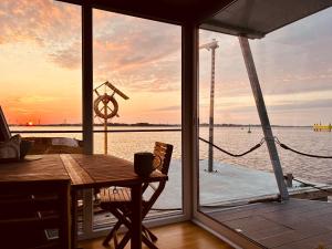 a room with a table and a view of the water at Mindset Houseboat - nocleg i apartament na morzu in Puck