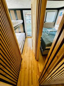 a room with two bunk beds and a wooden floor at Mindset Houseboat - nocleg i apartament na morzu in Puck
