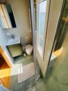 a bathroom with a toilet and a glass shower at Mindset Houseboat - nocleg i apartament na morzu in Puck