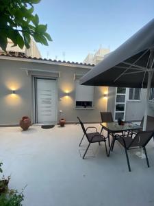 a patio with a table and chairs and an umbrella at Alexandra apartment in Athens