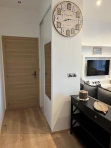 a room with a door and a clock on the wall at Appartement cosy au Centre in Montignac +25 photos