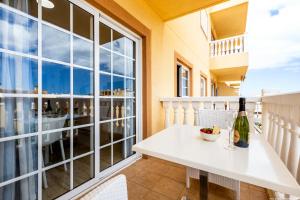 a white table with a bottle of wine on a balcony at Palm Mar Romantic Suite A21 in Palm-mar