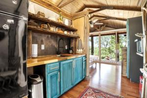 Una cocina con gabinetes azules y techo de madera. en SALIDA - Tiny Houses Of French Village, en French Village