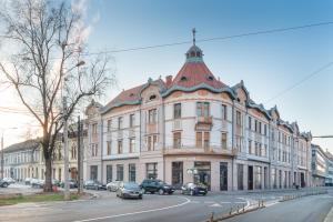 a large building on a street with cars parked on the street at Olimpia Residence in Oradea