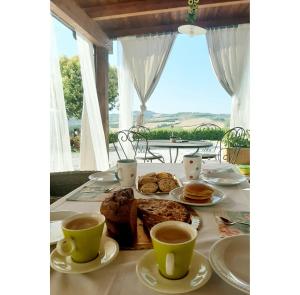 a table with food and two cups of coffee at Italian Experience-La Casa di Campagna in Molino di Carassai