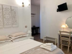 a bedroom with a bed and a table and a mirror at Italian Experience-La Casa di Campagna in Molino di Carassai