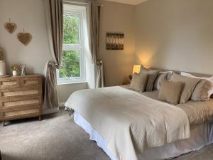 a bedroom with a large bed and a window at Serenity House Wales in Llangammarch Wells