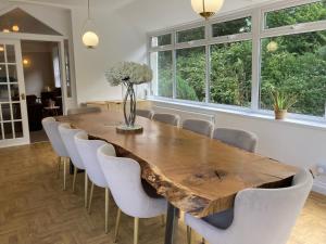a dining room with a wooden table and chairs at Serenity House Wales in Llangammarch Wells