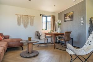 a living room with a couch and a table at Luxe 4 pers chalet op minicamping in waarde in Waarde