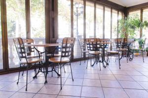 a row of chairs and tables in a room with windows at Hotel Alameda in Zarautz
