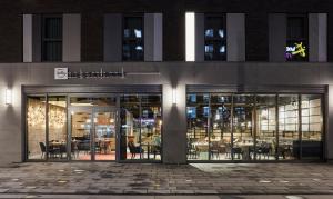 un restaurante con mesas y sillas fuera de un edificio en Hotel Indigo Berlin - East Side Gallery, en Berlín