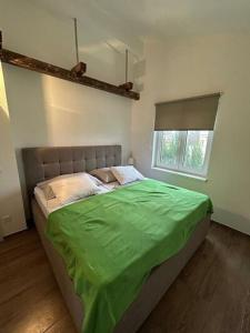 a bedroom with a green bed with a window at Apartment Letica 2 in Malinska