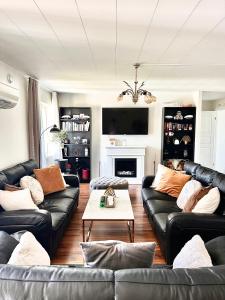 a living room with black leather couches and a fireplace at Huset som har allt! in Immeln +40 photos