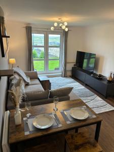 a living room with a table and a couch at Golf View in Prestwick