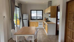 a kitchen with a table and chairs and a refrigerator at Naiwok Hills Resort in Haad Pleayleam