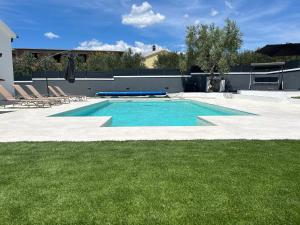 a large swimming pool with chairs and a lawn at Villa Sonja in Biograd na Moru +15 photos