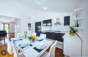 a kitchen and dining room with a white table and chairs at Villa Sonja in Biograd na Moru