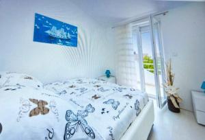a white bedroom with a bed with a butterfly blanket at Villa Sonja in Biograd na Moru
