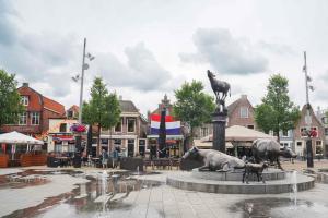 a statue of two bulls in a fountain in a city at Hotel Koemarkt in Purmerend